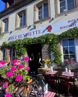 Un restaurante llamado 'Chez Henriette' con terraza y un letrero que indica que es un bistró.