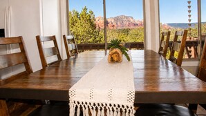 Una mesa de comedor con sillas, un posavasos tejido y un centro de mesa con planta.