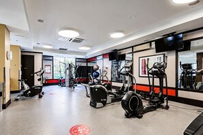 A gym with cardio machines, weight equipment, and mirrors.
