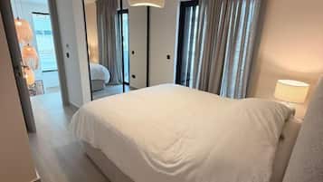 Tabla de planchar con plancha y ropa de cama