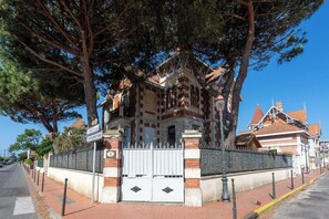 A historic building with a gated entrance, brick facade, and traditional architecture. - Villa Le Cid *Charm, Elegance, and the Beaches of Soulac* (Soulac-sur-Mer)