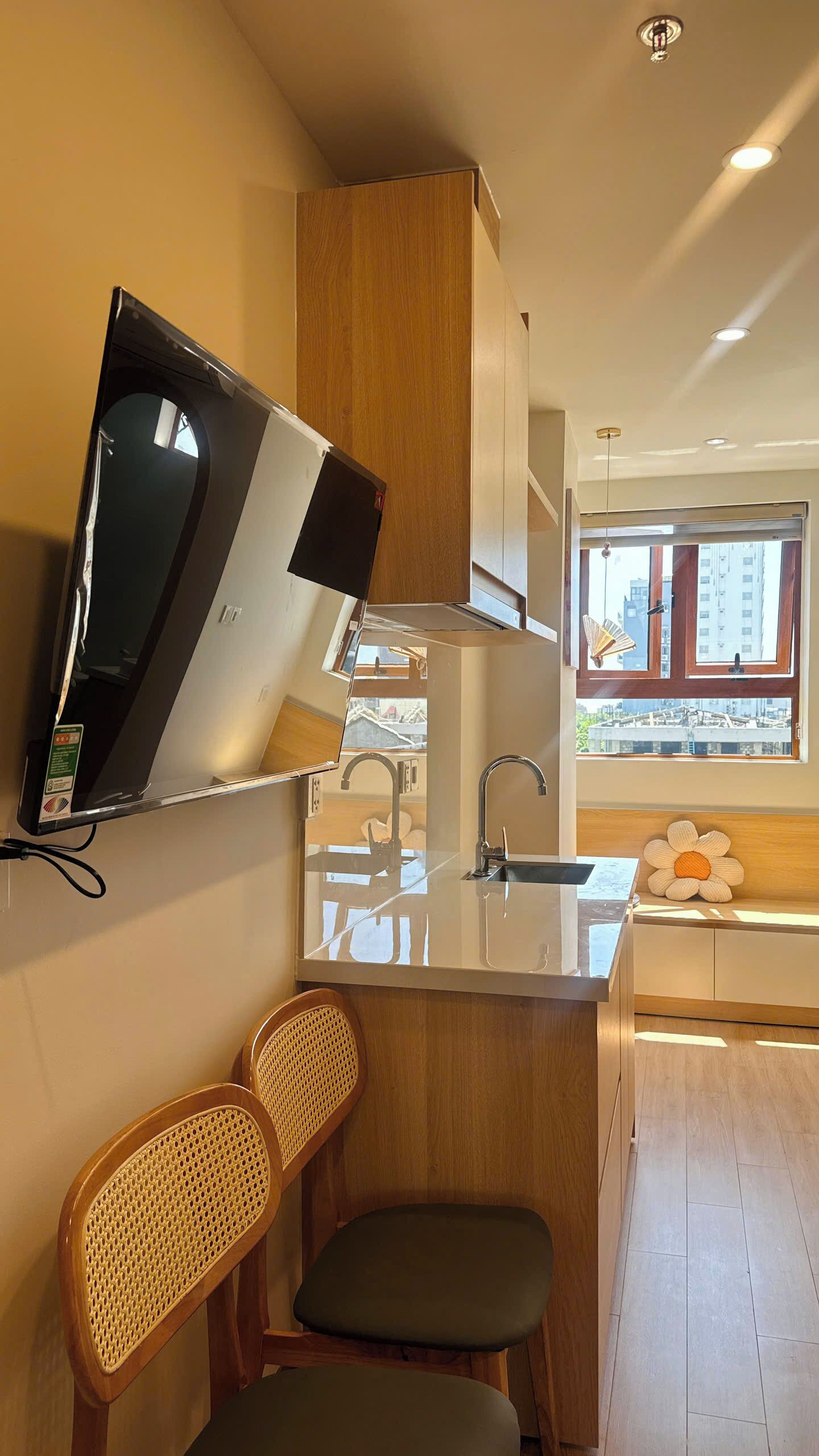 A modern kitchen with a built-in microwave, a sink, and a window with a view of buildings.