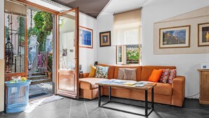 Un salon comprenant un canapé, une table basse et une porte vitrée donnant sur un balcon.