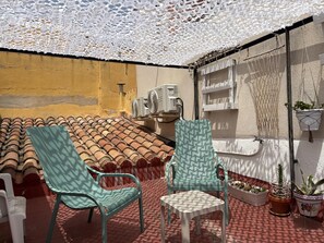A covered outdoor seating area with two chairs, a small table, and potted plants. - Detached house in Tarragona's historic center (Tarragona)