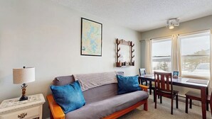 Una habitación acogedora con un sofá, una mesa de comedor y un mapa en la pared.