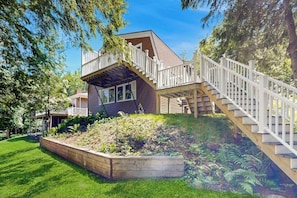 A house with a wooden deck, a staircase, and a garden. - Heart Pond Hideaway (Orland)