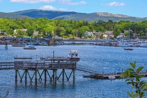 A waterfront marina with boats, a dock, and houses in the background. - Woodland Home Near Long Pond w/ Spacious Living Area, Full Kitchen & Deck (Mount Desert)