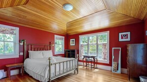A room with a wooden ceiling, a bed with white bedding, a wooden bench, a table, and a dresser. - Parker House: Historic Home - Walk Downtown, Dog-friendly & Washer/dryer (Camden)