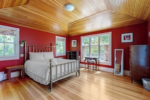 A room with a wooden ceiling, a bed with white bedding, a wooden bench, a table, and a dresser. - Parker House: Historic Home - Walk Downtown, Dog-friendly & Washer/dryer (Camden)
