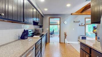A kitchen with dark wooden cabinets, granite countertops, and stainless steel appliances.