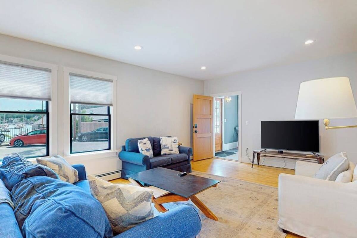 A modern living room with a sofa, a coffee table, a TV, and a lamp.