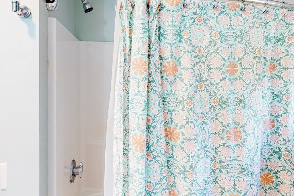 Ein Badezimmer mit Badewanne, Dusche und einem waschbärbeliebigen Duschvorhang.