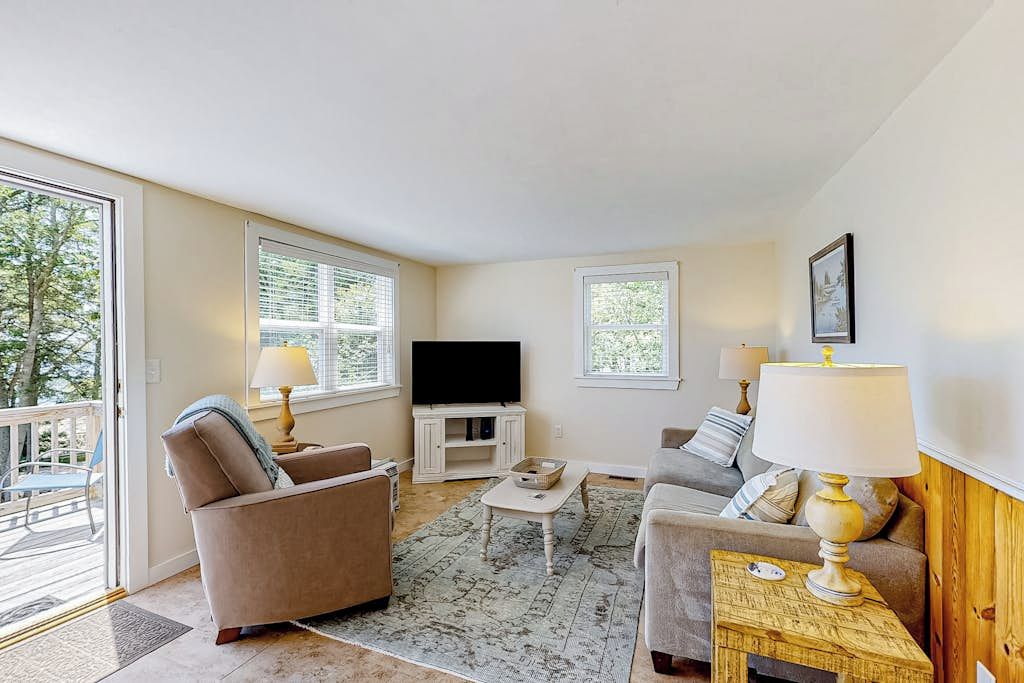 A living room with a sofa, a coffee table, a TV, and a lamp.