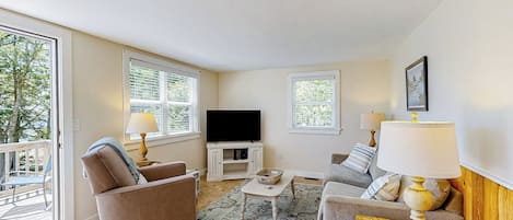 A living room with a sofa, a coffee table, a TV, and a lamp.