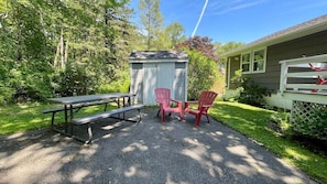 A picnic setup with a table and chairs, a shed, and a house with a fence. - Penobscot View, 4 Bedroom Home in Rockland Maine (Rockland)