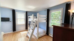 A room with a bunk bed, a desk, a chair, a TV, and a window. - Penobscot View, 4 Bedroom Home in Rockland Maine (Rockland)