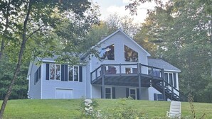 A two-story house with a balcony and a staircase leading to the upper floor. - Riverfront Home w/ Deck, Amazing Views & Firepit - Near the Best of Maine (Stockton Springs)