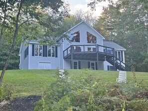 A two-story house with a balcony and a staircase leading to the upper floor. - Riverfront Home w/ Deck, Amazing Views & Firepit - Near the Best of Maine (Stockton Springs)