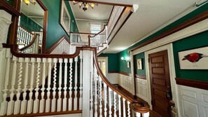 A grand staircase with white balusters and a wooden handrail, leading to a landing with a door marked '13'. - Commanders Cabin, Quaint apt Steps to Downtown (Camden)