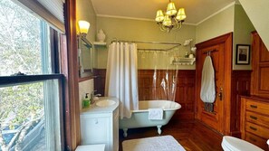 Een badkamer met een badkuip, wastafel, spiegel en douchegordijn.