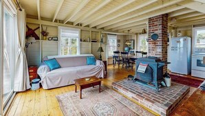 Ein gemütliches Wohnzimmer mit einer Couch, einem Couchtisch, einem Kamin und einem Essbereich mit Stühlen und einem Tisch.