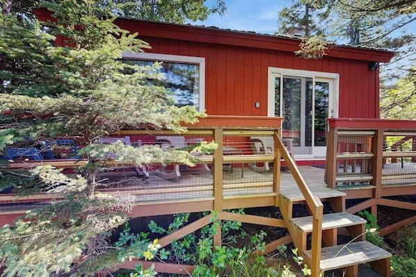 A red cabin with a wooden deck and a glass door. - Secluded Sunset Point Mountain top Cabin, Wifi, Dish TV, Firepit (Bar Harbor)