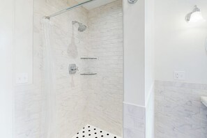 A shower with a glass door, a handheld showerhead, and a wall-mounted faucet. - Beautiful Home With Ping-pong, Fast Wifi & W/D - Walk to Dining (Wiscasset)