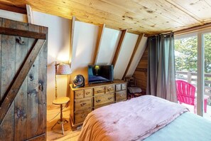 A bedroom with a bed, a dresser, a TV, and a window with curtains. - Waterfront A-frame on George's Pond With Views, Private Dock, Beach, Kayaks, SUP (Franklin)
