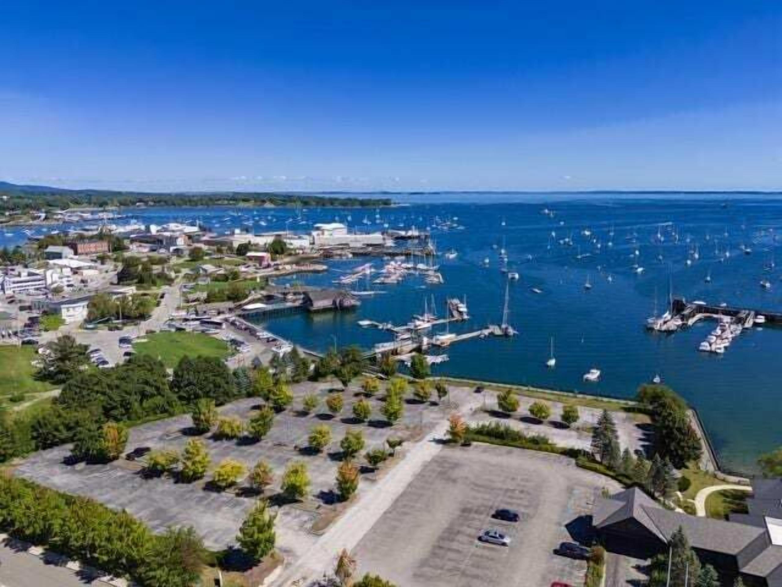 Un puerto deportivo con barcos, un aparcamiento y edificios.