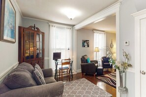 A living room with a sofa, chairs, a cabinet, and a dining table. - Corbel House (Bucksport)