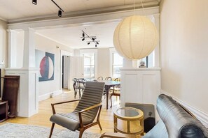 Ein großzügiger Wohnbereich mit einer Ledersofa, einem runden Couchtisch und einem Essbereich mit einer Chandelier.