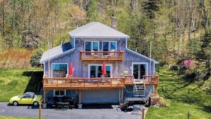 Ein zweigeschossiges Haus mit Balkon, Garage und Auffahrt.