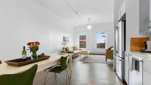 A modern kitchen with a dining area, a sofa, and a view of the outside. - Rockland Central (Rockland)