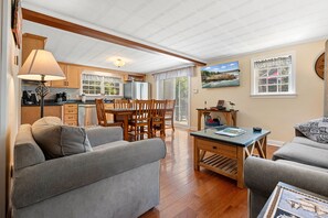 A cozy living room with a sofa, a coffee table, and a dining area with chairs and a table. - Boothbay Harbor Home With Water Views Near Dining & Whale Watching (East Boothbay)