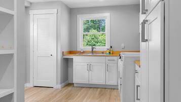 A kitchen with white cabinets, a window, and a sink.