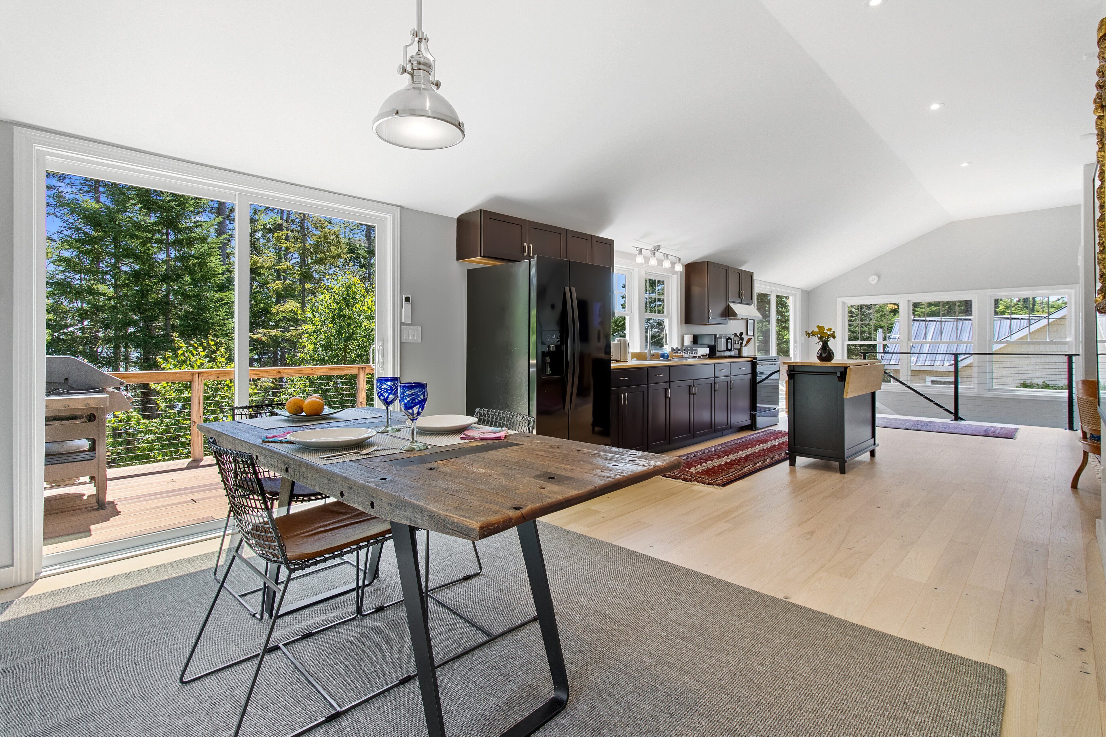 A spacious kitchen with a large island, dark wooden cabinets, and a view of the outdoors.