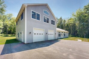 Ein zweistöckiges Haus mit Garage, überdachter Veranda und Auffahrt.
