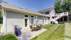 A house with a patio, a covered grill, and a staircase to an upper level. - Newly Renovated Home w/ Large Yard & Great Kitchen - Near Downtown & Acadia (Bar Harbor)