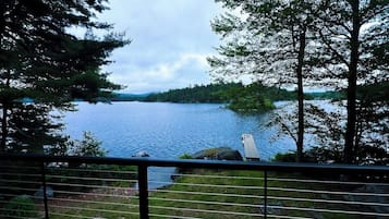 A lake with a dock, surrounded by trees and a railing.
