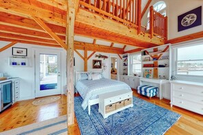 A spacious bedroom with a large bed, a wooden ceiling, and a view of the sea. - Oceanfront Cottage & Studio on Mill Cove w/ Water Views, Deck - Walk Downtown (Boothbay Harbor)