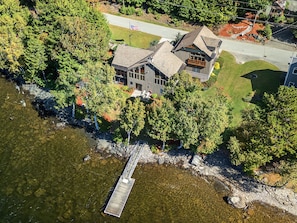An aerial view of a house with a dock extending into a body of water, surrounded by dense trees. - Lakeside Lodge With Amazing Water Views, Screened Porch, Dock, & Firepit (Greenville)