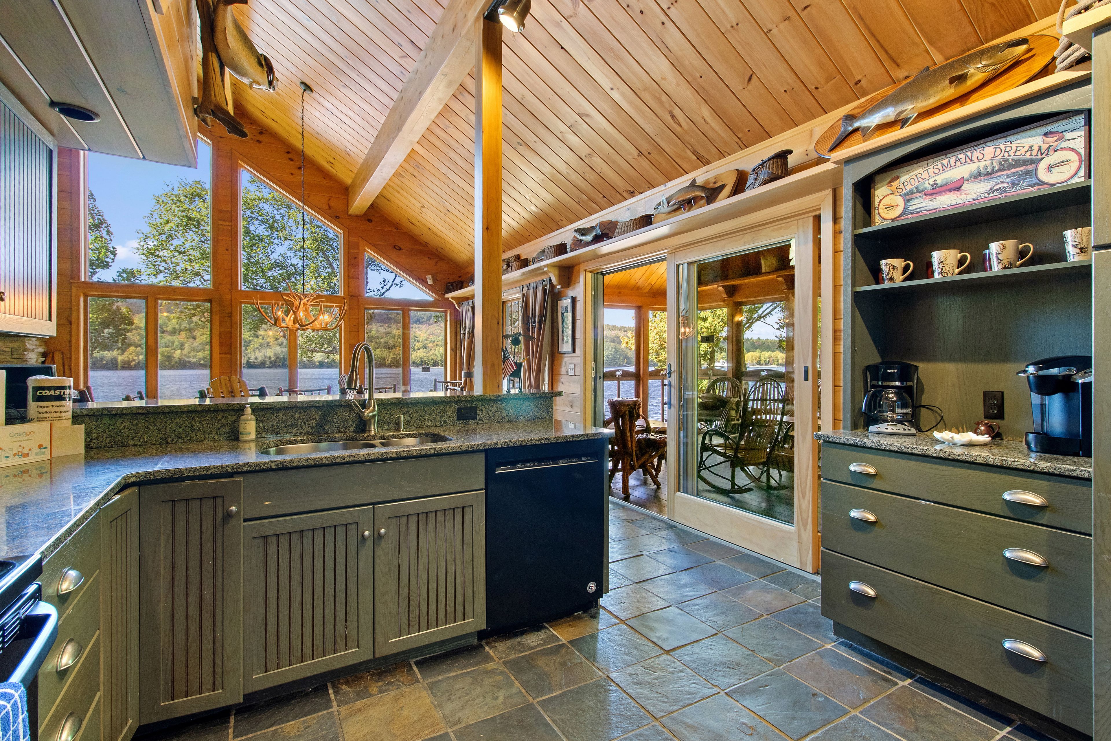 A kitchen with a large island, granite countertops, and a view of the outdoors.