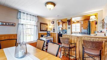 A cozy dining area with a wooden table, chairs, and a kitchen in the background.