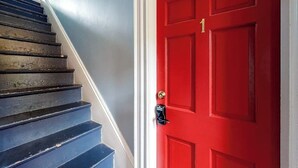 A red door with a number '1' and a black security device.