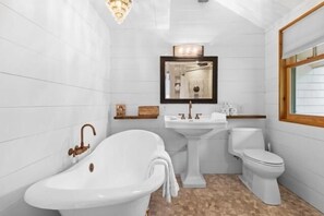 A bathroom with a freestanding bathtub, a pedestal sink, and a toilet. - Bee Hive Cottage, Romantic Maine Waterfront Cottag (Cushing)