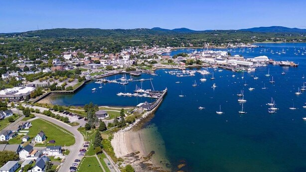 An aerial view of a coastal town with a marina, houses, and a beach. - Kimball Apartment, Modern Studio on Main Street Ro (Rockland)