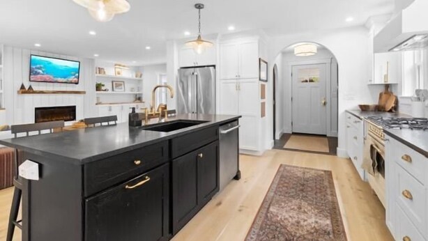 A modern kitchen with a central island, white cabinetry, and a built-in oven. - Birch Tree Retreat, 6-bedroom Family Getaway Spot (South Thomaston)