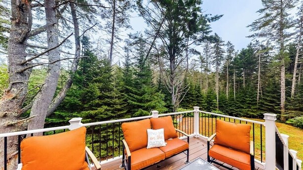 A deck with two orange cushioned chairs and a small table, surrounded by a white railing. - Idyllic Waterfront Home With Furnished Deck, Grill, Sweeping Views & Private W/D (Waldoboro)