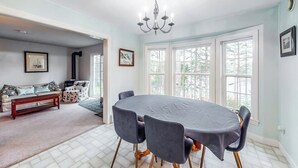 A dining area with a table, chairs, and a chandelier. - Idyllic Waterfront Home With Furnished Deck, Grill, Sweeping Views & Private W/D (Waldoboro)
