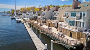 A waterfront property with a dock, boats, and a row of houses with balconies. - Bay View on Camden Harbor Condo 2br, 2 Baths, AC, Fireplace (Camden)